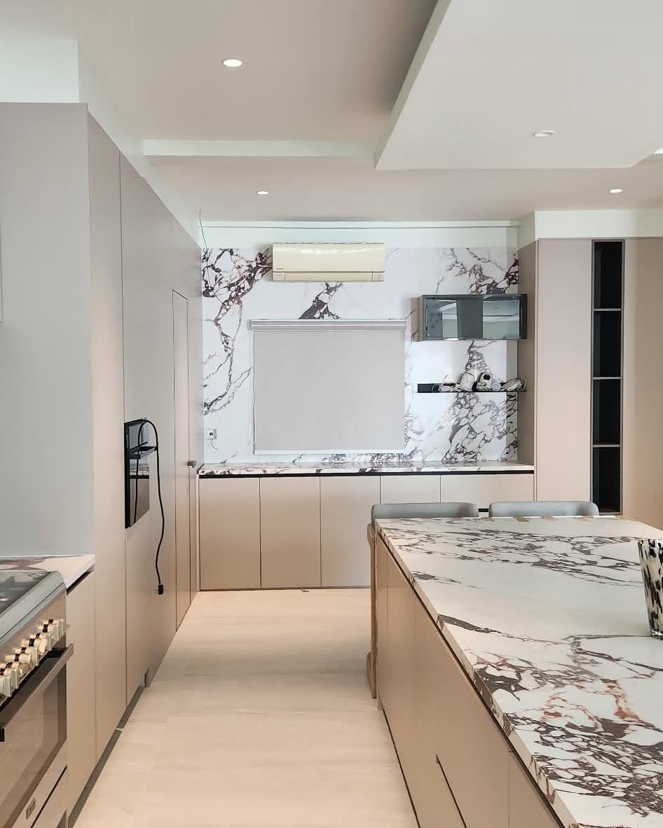 Smooth light-colored roller blind installed in a modern luxury kitchen, compact and easy to maintain