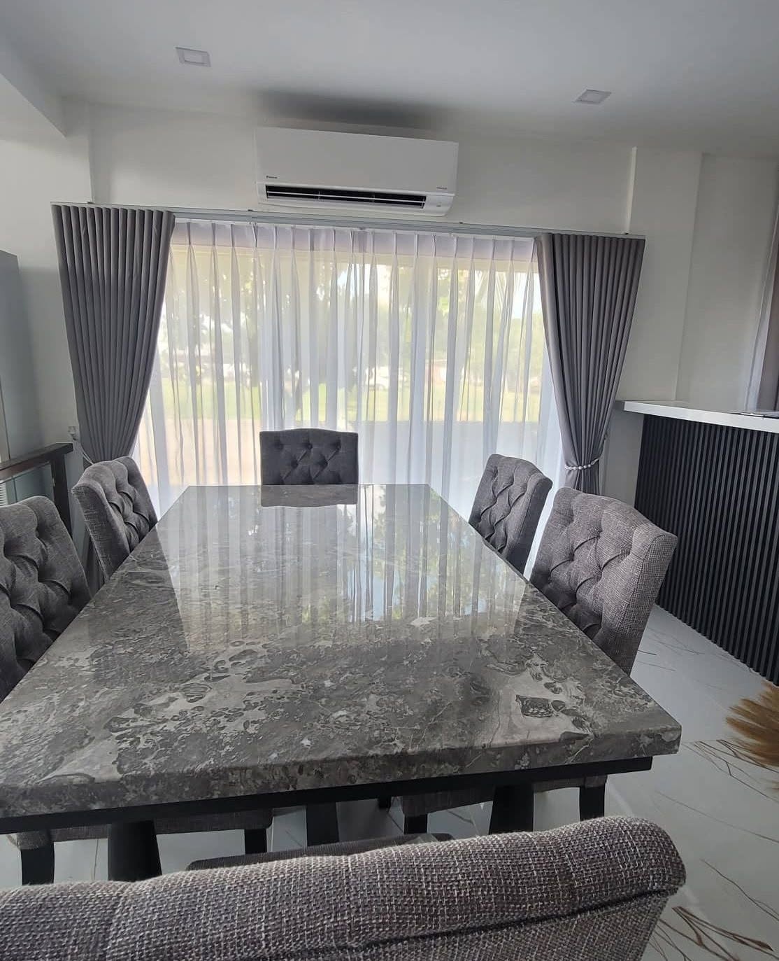 Modern dining area with gray blackout curtains and white S-fold sheers, neat and elegant