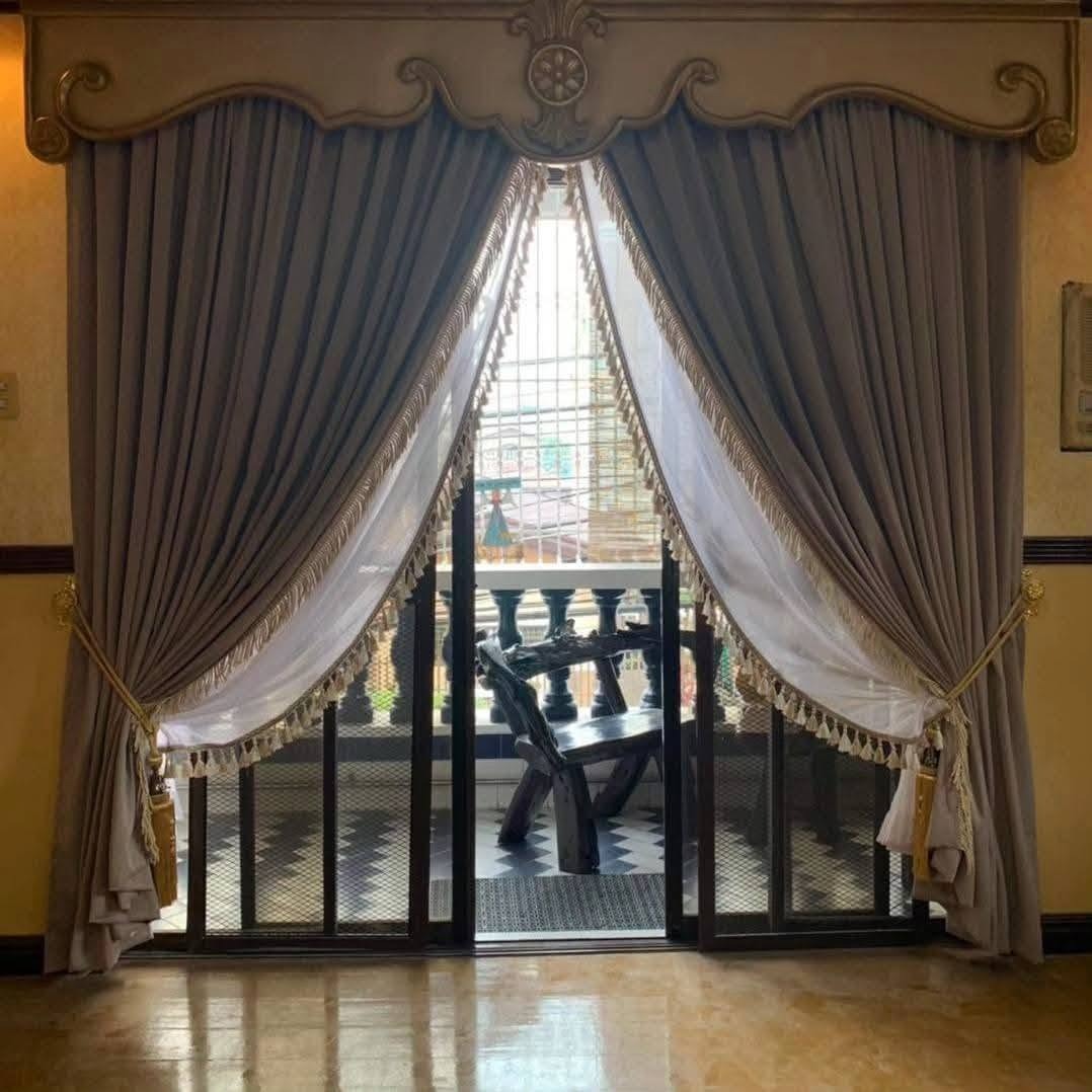 Elegant traditional curtains with decorative valance, grey drapes and fringed sheer panels