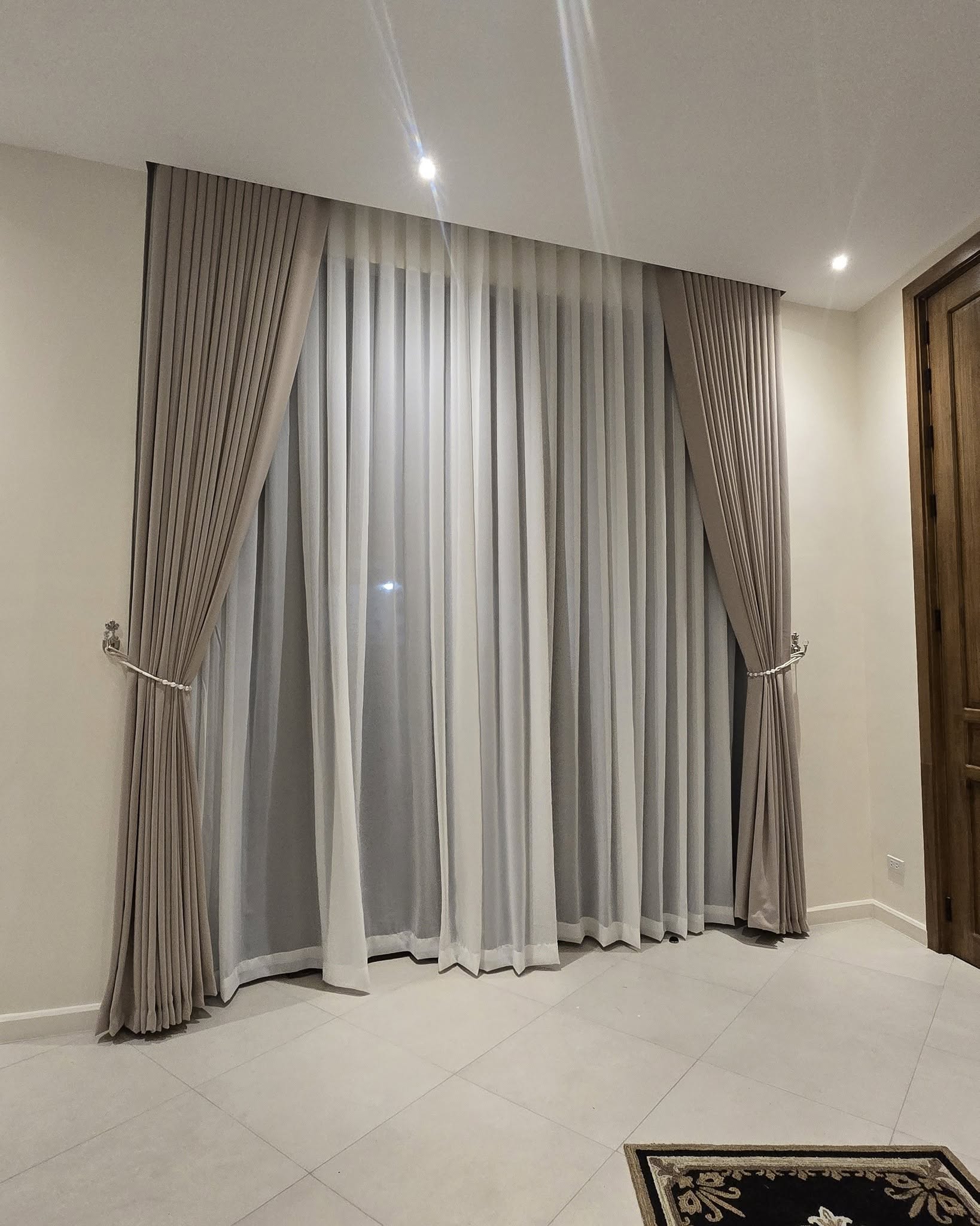 Premium layered curtains: taupe blackout drapes with white S-fold sheers, custom pleat finish